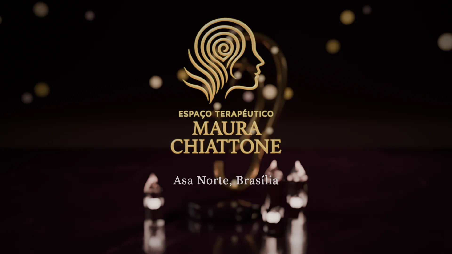 Logotipo do Espaço Terapêutico Maura Chiattone com a legenda Asa Norte, Brasília, à frente de uma escultura dourada de orelha com cristais rosados